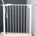 Barrière de sécurité moderne blanche pour enfants près dun escalier en bois.