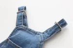 Bretelles en denim bleu avec clips métalliques pour un style décontracté et pratique.