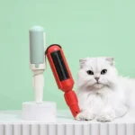 Chat blanc tranquille avec outils de toilettage modernes mint et rouge.