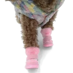 Chien cur curly avec bottes roses et manteau coloré, plein de joie en mouvement.