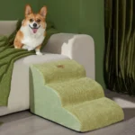 Corgi joyeux sur canapé avec escaliers pour chien dans un intérieur chaleureux et accueillant.