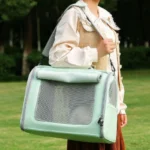 Femme avec un sac de transport pour animal vert menthe dans un parc verdoyant.