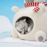 Lit pour chat en forme de bonhomme de neige avec un chat blanc dormant.