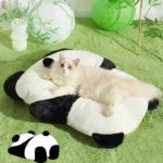 Chat blanc détendu sur un lit panda douillet dans un intérieur apaisant.