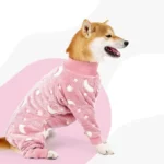 Shiba Inu mignon en pyjama rose avec motifs lunaires et étoilés, confort assuré.