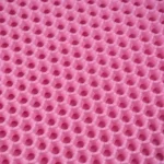 Surface rose synthétique texturée avec motif alvéolé, idéale pour créations ludiques et décoratives.