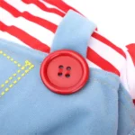 Vêtement coloré pour enfant : combinaison bleue avec bouton rouge et tissu rayé.