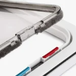 Appareil électronique moderne avec cadre blanc, surface transparente et boutons colorés.