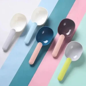 Cuillères colorées en plastique sur fond pastel, parfaites pour égayer votre cuisine.