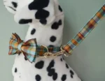 Jouet en peluche Dalmatien avec collier à nœud et laisse colorée, idéal pour les enfants.