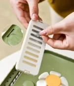 Dispositif blanc pour cuisine moderne, mains en action pour la préparation alimentaire.