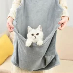 Personne avec un chat dans une poche dun tablier gris confortable et cosy.