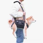 Personne portant un Shiba Inu dans un porte-chien noir, confort et style en déplacement.