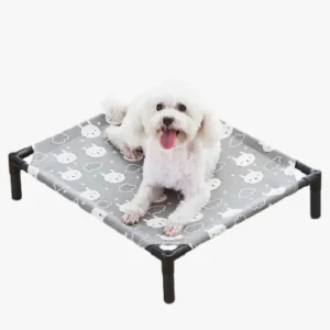 Lit douillet pour chien avec un chien heureux sur une couverture grise.