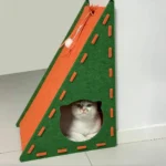 Un chat blanc dans une niche-griffoir multifonction en feutre