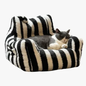 Un chat noir et blanc allongé confortablement sur le canapé pour animal.