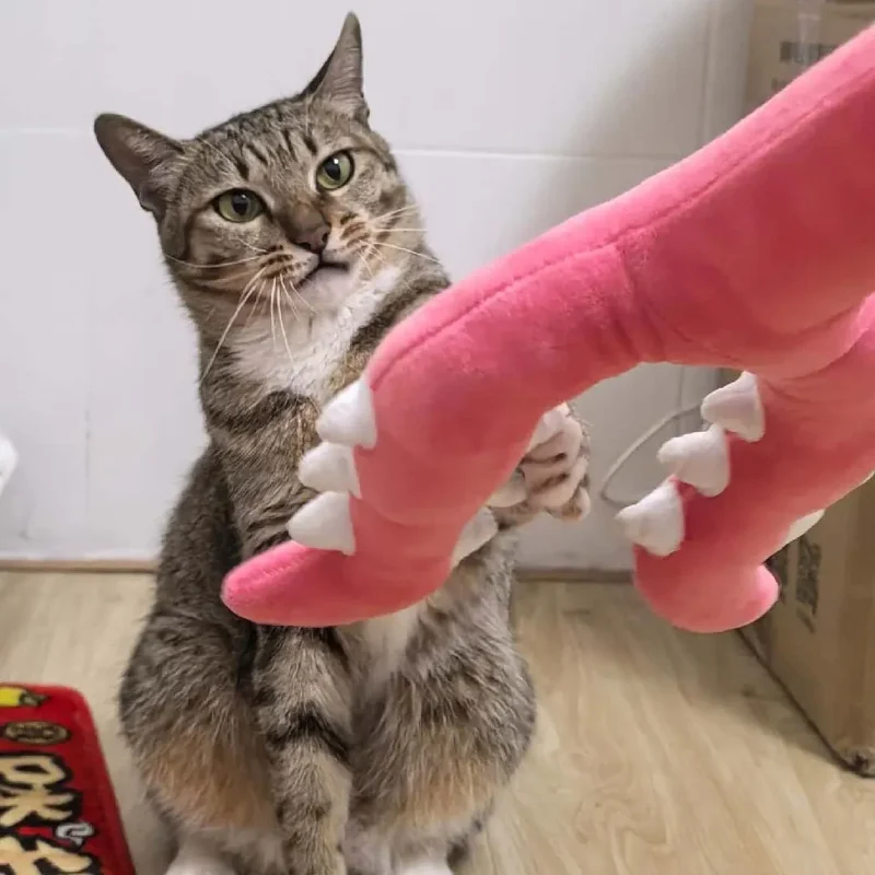 Un chat tigré joue avec un jouet pour chat rose en fourche peluche